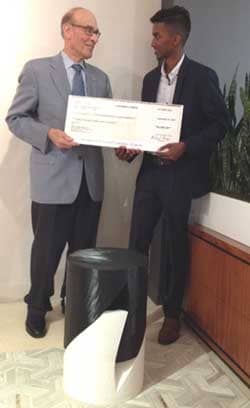 Competition winner Karunadhipathi Lihin Weera accepts a giant version of his $3,000 scholarship check  from Mervyn Kaufman, representing IFDA&#39;S Educational Foundation.