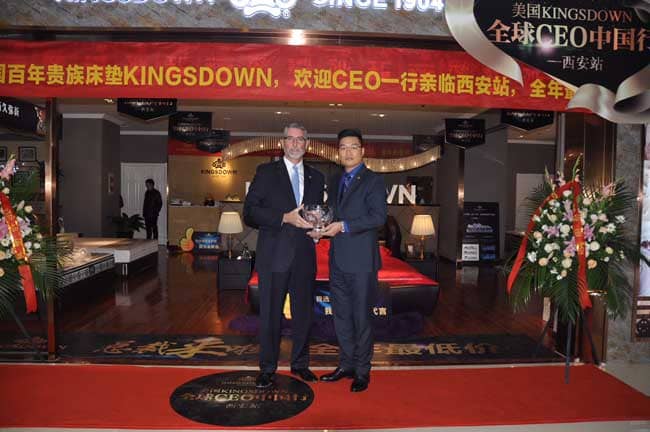 Frank Hood, president and CEO of Kingsdown, left, presents Jai Du, general manager of Kingsdown China, with a crystal bowl to mark the store’s opening.