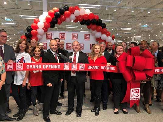 Attendees at the official ribbon cutting ceremony included Store Manager Derrick Dresmal (center holding scissors) and Village of Kildeer President Nandia Black (red blazer holding ribbon). 
