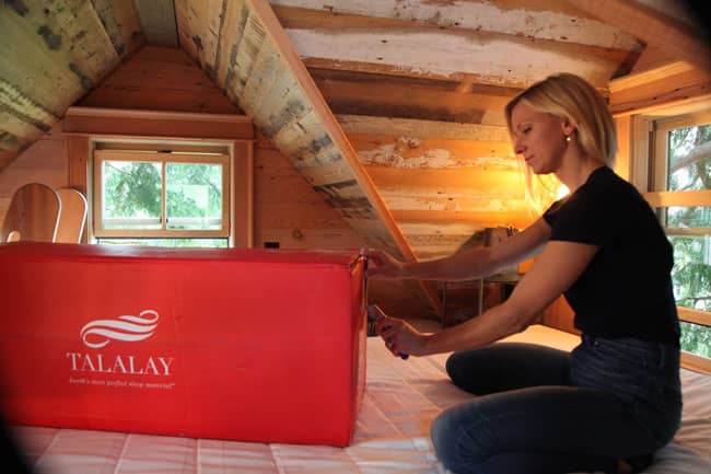 Interior designer Christina Salway opens a carton of Talalay Latex pillows inside an Alabama treehouse she designed for the popular Animal Planet show “Treehouse Masters.”
