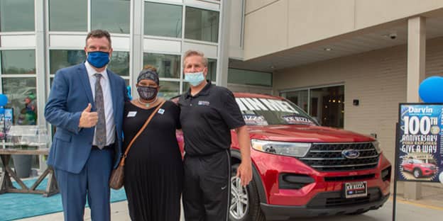 Darvin Furniture President Will Harris (left) and Dan McMillan of Rizza Ford stand with Darvin 100th Anniversary grand prize winner Bridget Kincy-Pollard, who took home a 2020 Ford Explorer.