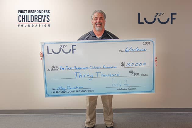 Symbol President Mike McQuiston holds a check for $30,000 donated to the First Responders Children’s Foundation.