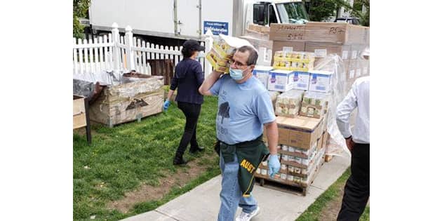 Volunteers unload canned goods at Commpoint Queens, one of the many facilities supported by Bob’s donations to food pantries across the country.