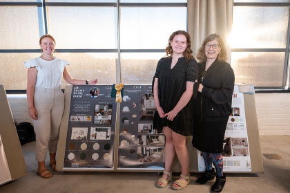 Hannah Robertson, pictured left, and Gabrielle Lozon, center, with Dr. Jane Nichols and the winning design prototype they created for the J.H. Adams Inn using Culp products.